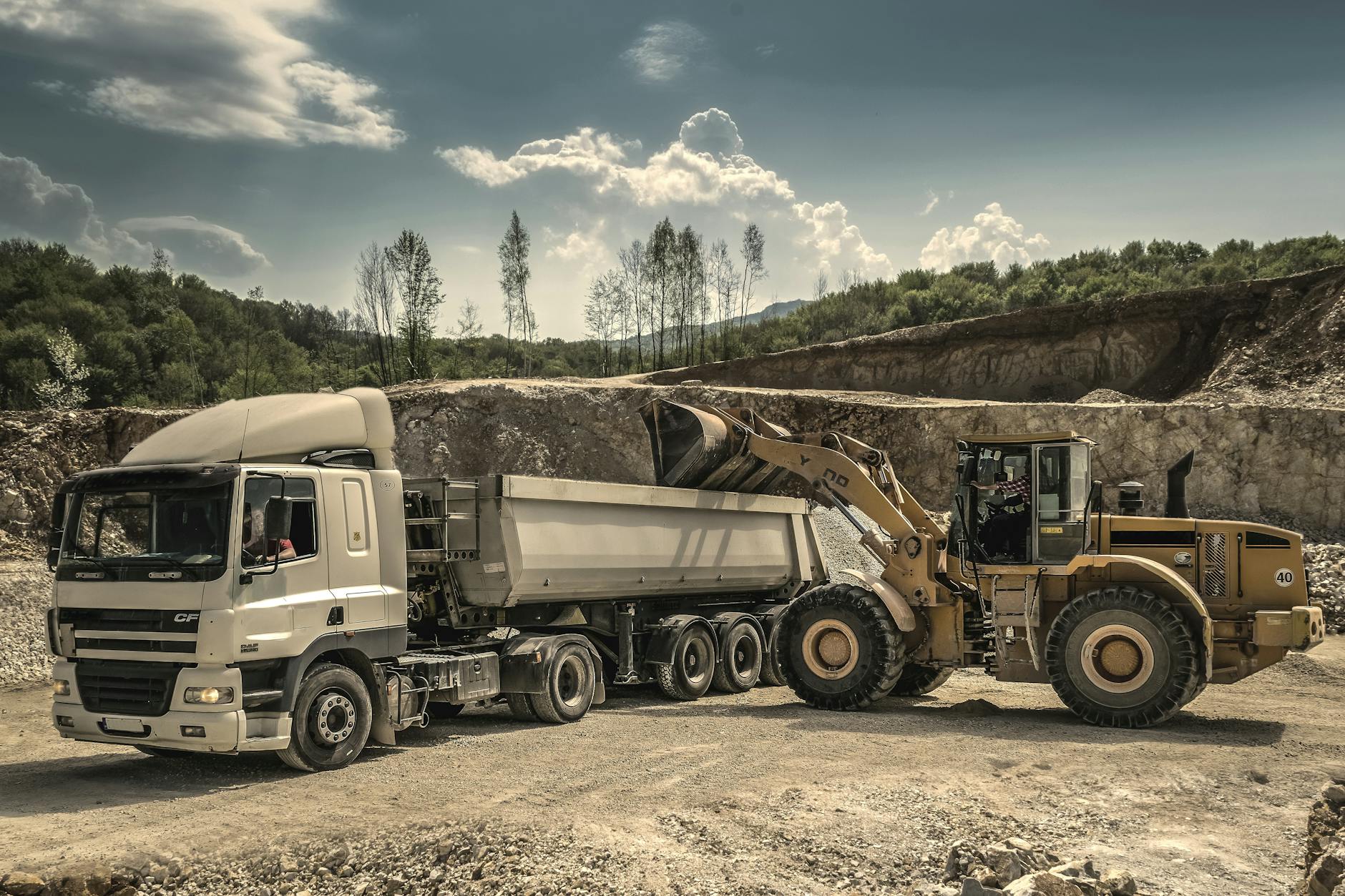 front load loader beside white dump truck